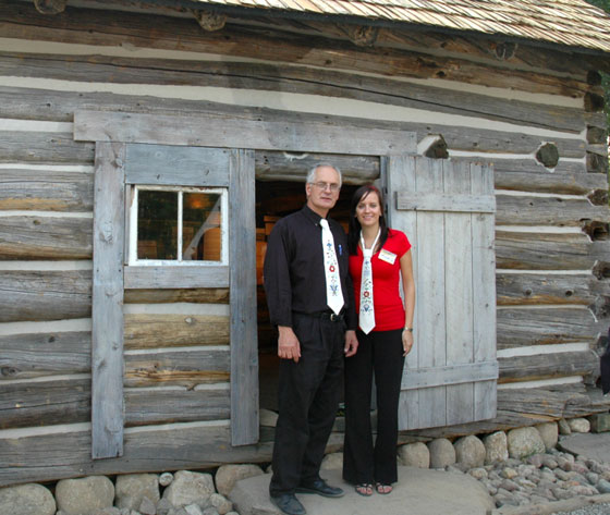 Ed and Sarah Chippior in front of the log house