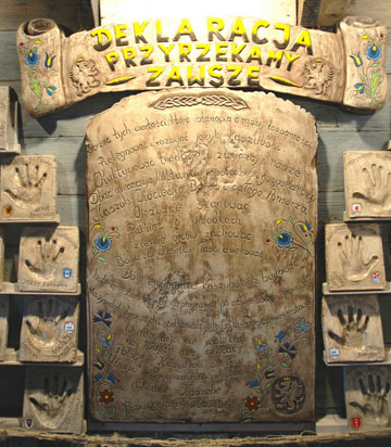 Plaque containing the declaration, surrounded by smaller plaques containing handprints in clay.