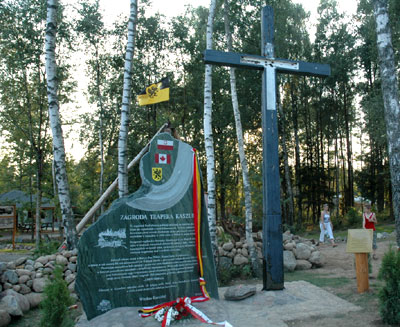 Large stone with inscription beside wooden cross